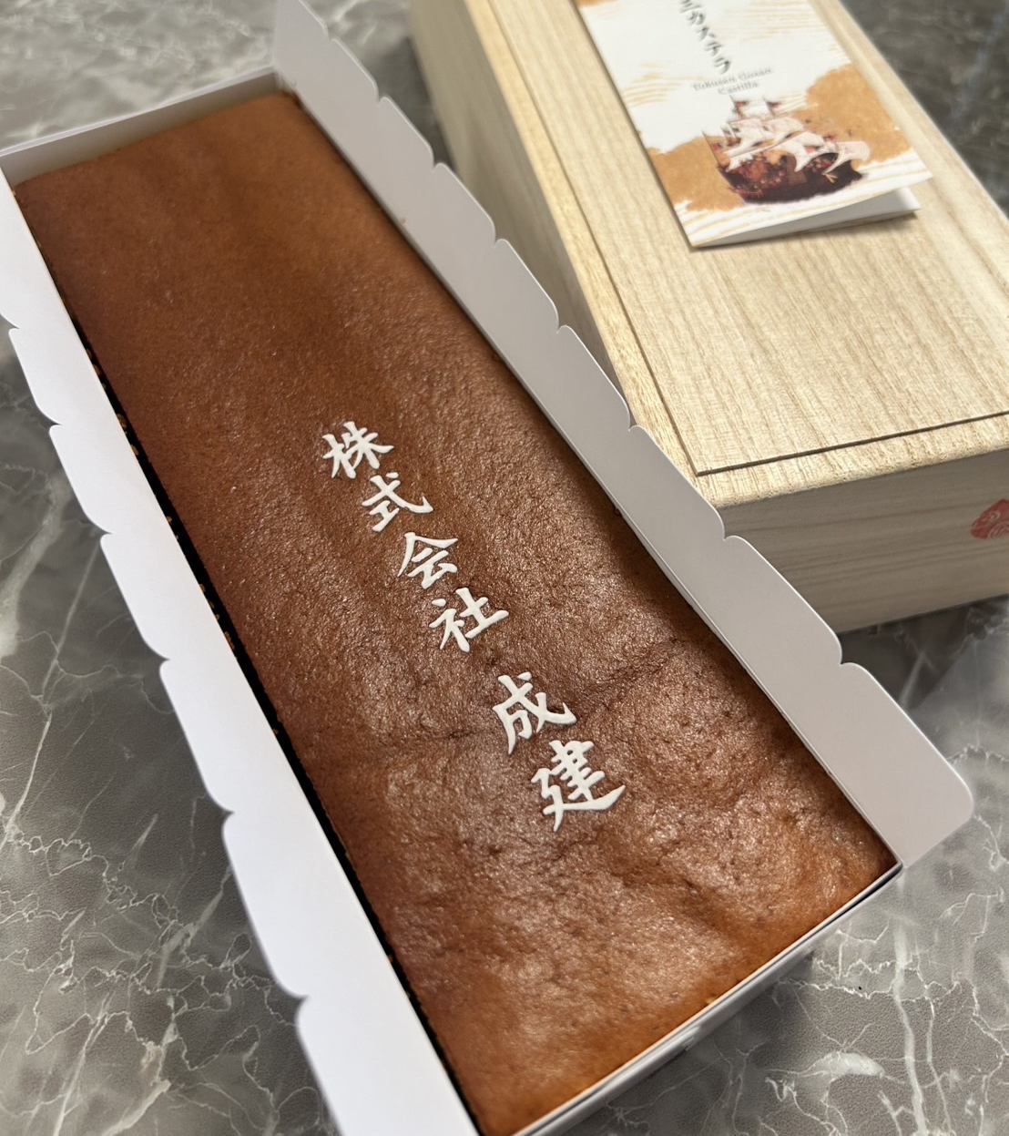 お土産は、社名の焼き印入り特製カステラです。